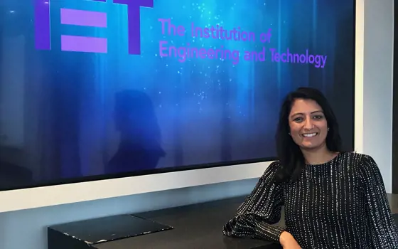 Mamta Singhal in front of a logo for the Institution of Engineering and Technology.
