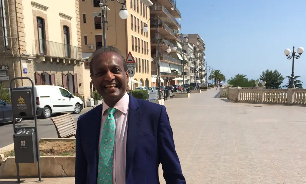 Dr Rajapillai (RV) Ahilan on a sunny beachside promenade in Italy.