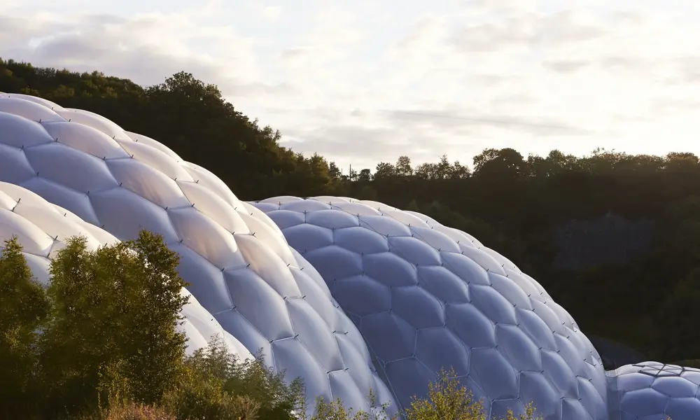 The plastic covered geodesic domes of the Eden Project seen below a bright but cloudy sky.