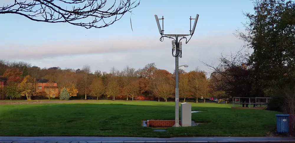 A 4G small cell tower in a green field at the University of Surrey.