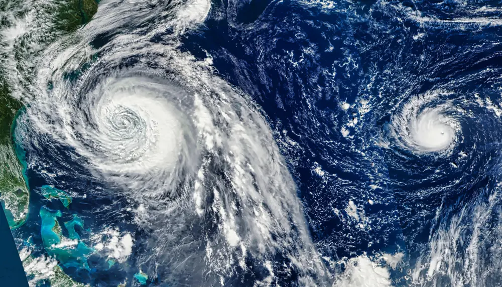 Satellite imagery of two hurricanes seen above the Atlantic Ocean, near the coast of the Americas