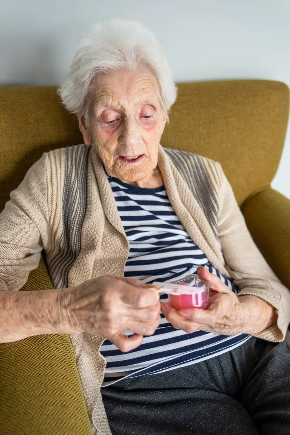 An older woman opening a pot of pink Jelly Drops sweets