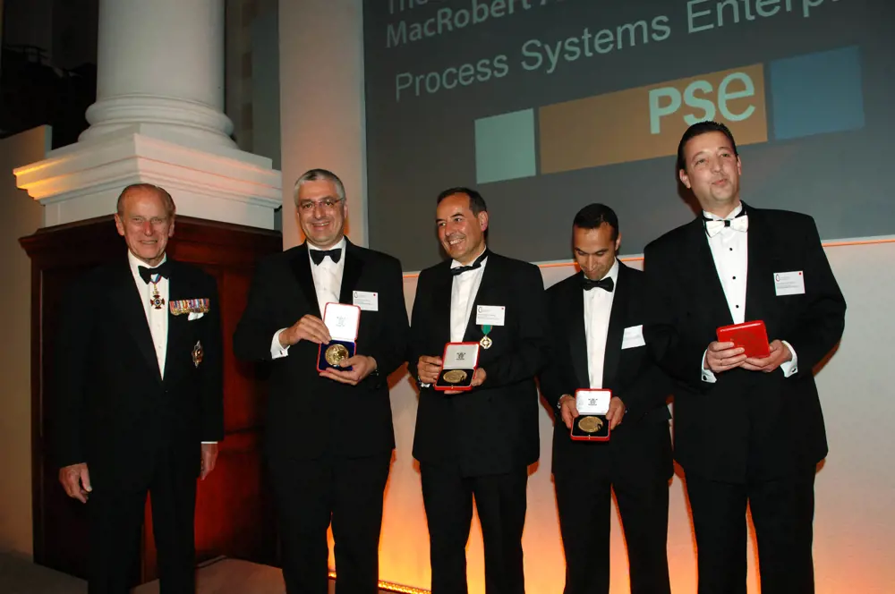 Five men in black tie with four holding medals. The fifth man on the far left is HRH The Duke of Edinburgh