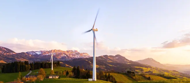A wind turbine on a hillside in the mountains