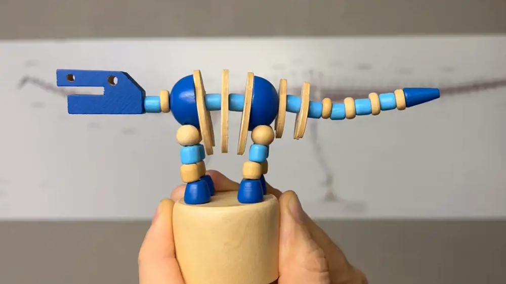 A toy dinosaur made of blue and beige wooden beads