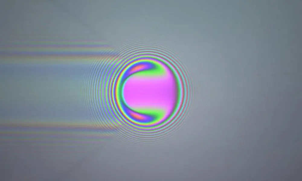 Coloured optical interference fringes around a ball.