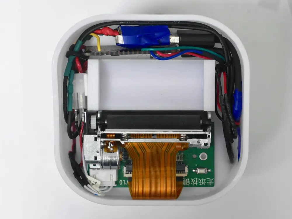 A prototype of a printer opened up, showing its circuitry and electronics.