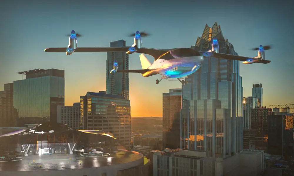 An electric plane taking off in a city from a helicopter landing pad.