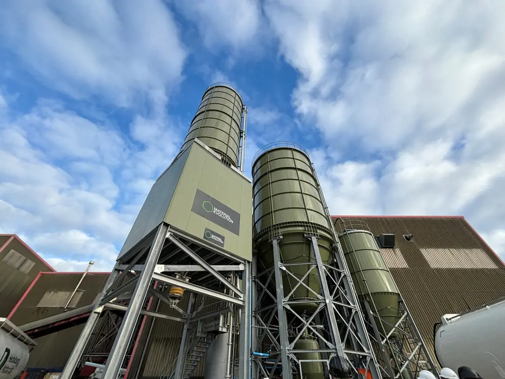 A chemical plant seen from below, with a slightly cloudy blue sky above.