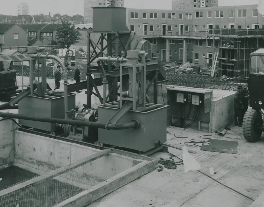 A grayscale image of twin 12-inch diameter hydrocyclone units outside with houses in the background.