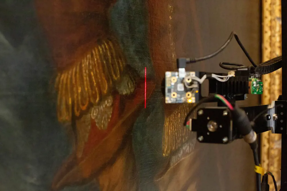 A 3D scanner with a laser moving over the surface of a van Dyck painting. 