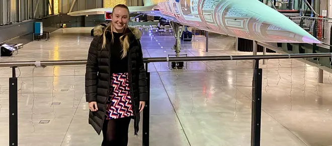 Person standing in a museum gallery beside a Concorde aircraft, with the plane’s nose and exhibition space visible behind.