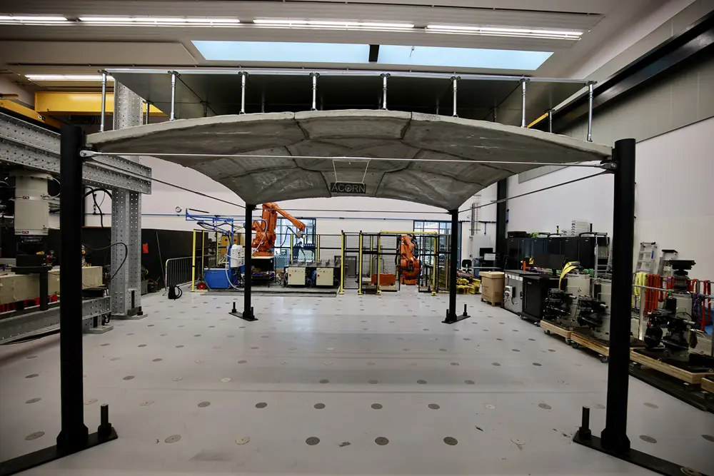3D‑printed concrete canopy structure supported by four columns in a research laboratory.