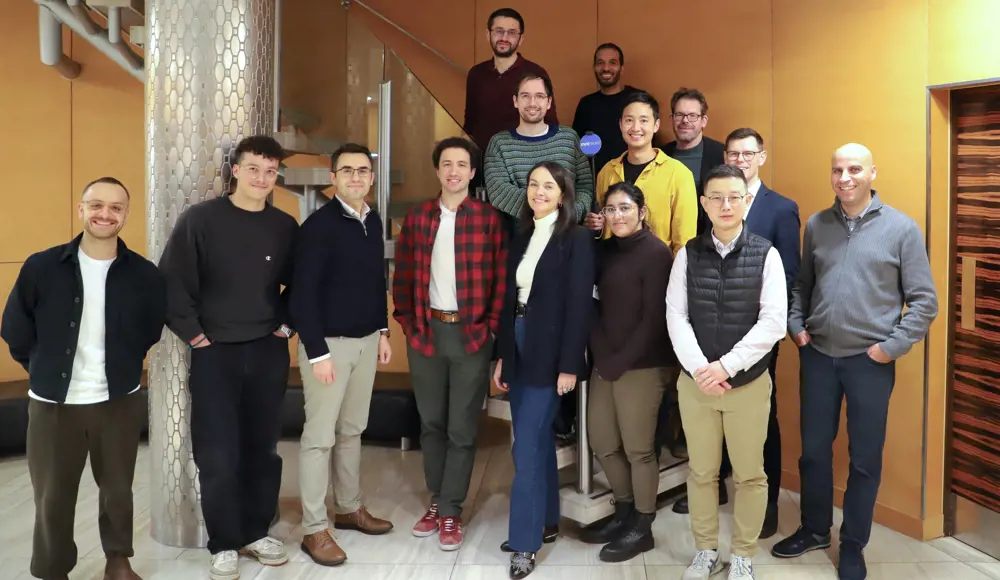 A group of people pose for a photo, with some standing on a staircase