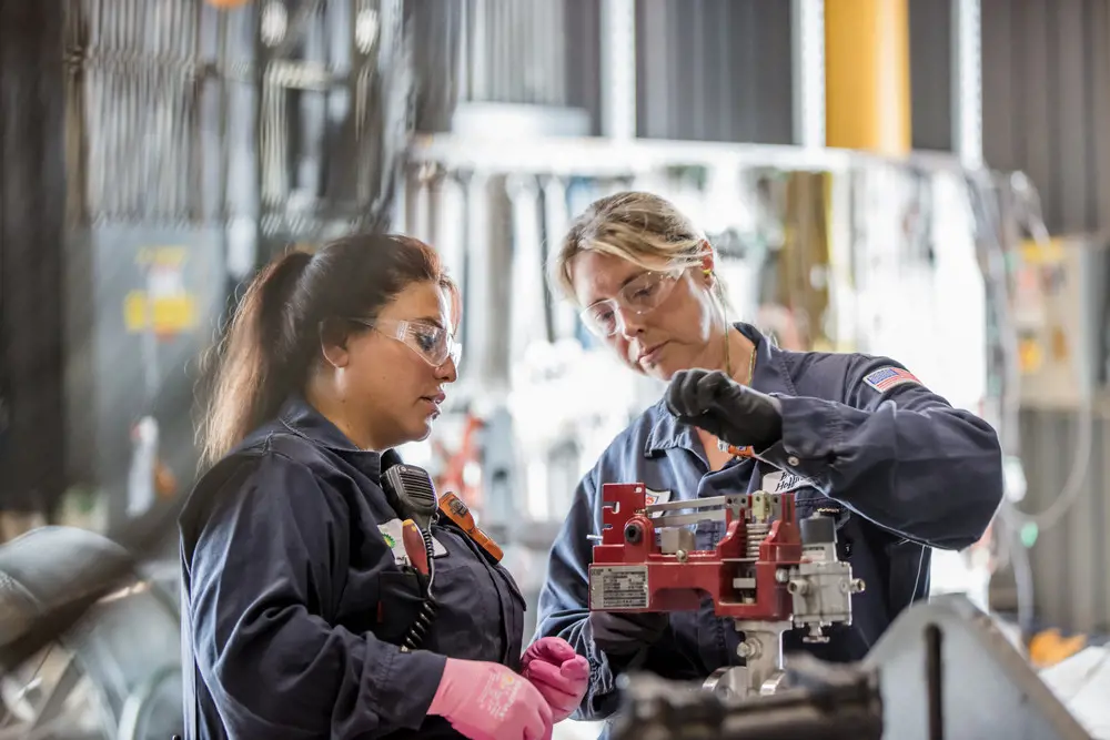 Two female refinery engineering technicians at BP in a factory.