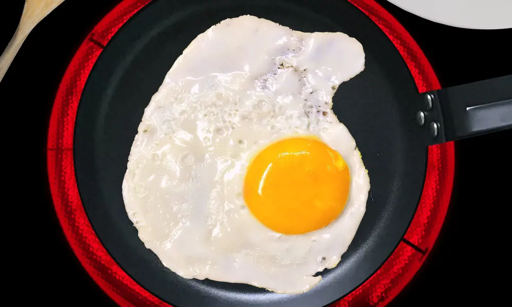 A fried egg in a pan on an induction hob.