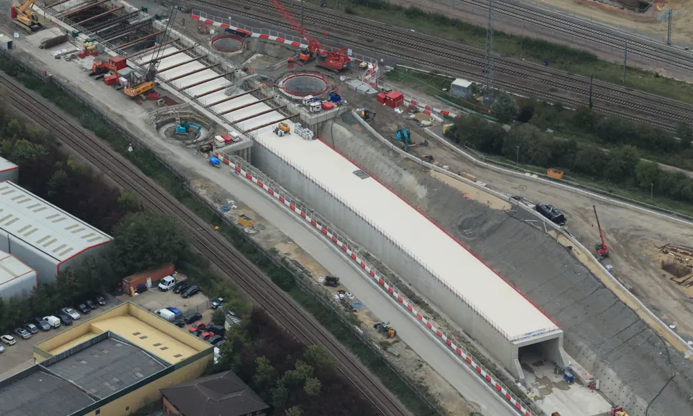 Aerial shot of multiple rail tracks with the construction of a tunnel between them.