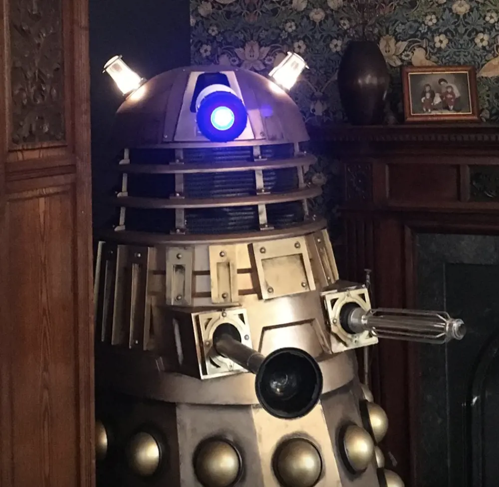 A Dalek, which looks like a robotic tank-like machine, inside a house. 