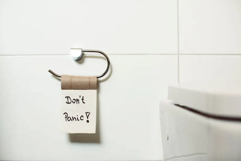 The last sheet of a toilet roll. Someone has written "Don't Panic!" on it in black marker pen.