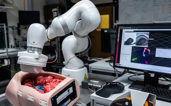 A computer display, whose interface can guide a robotic arm with a magnetic appendage above a model of the colon.