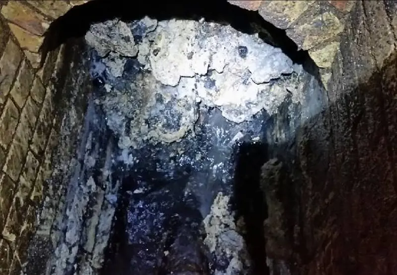 A tunnel in the London underground sewer with a large fatberg blocking it.