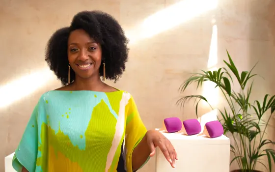 A woman with an afro standing in front of three specialist detangler combs.