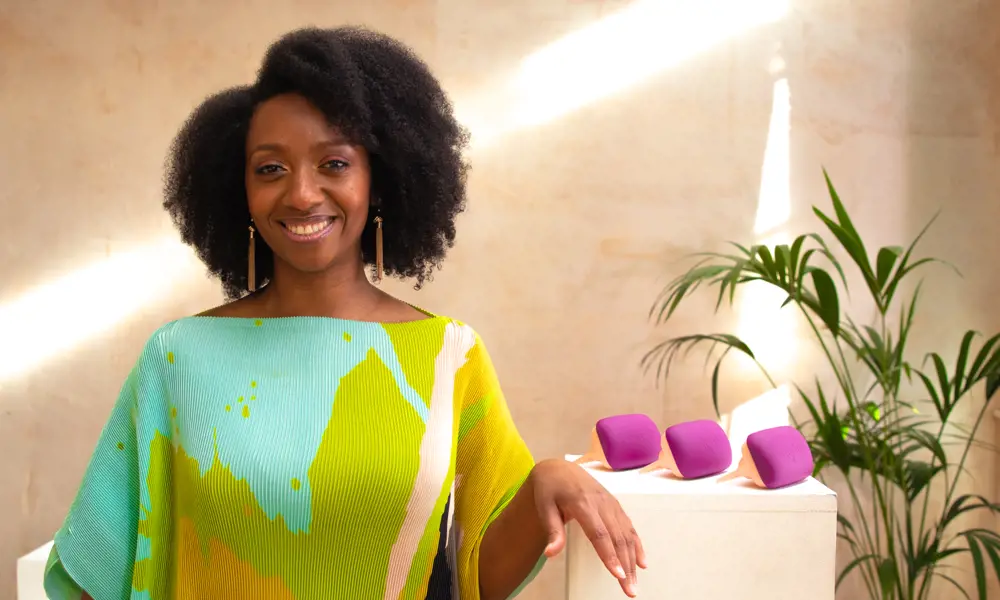 A woman with an afro standing in front of three specialist detangler combs.