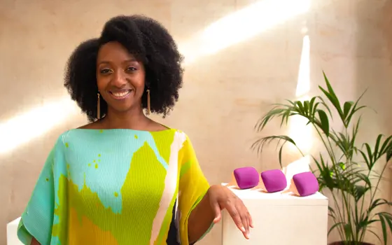 A woman with an afro standing in front of three specialist detangler combs.