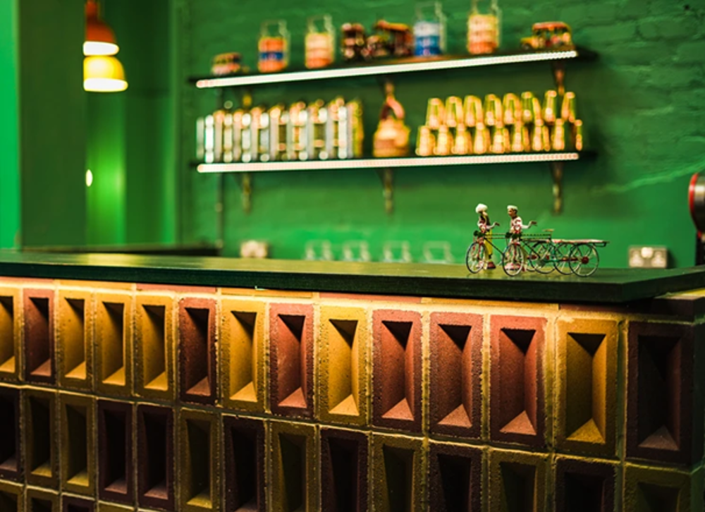 A bar stand made of K-Briq's with liquor on shelves in the background. 