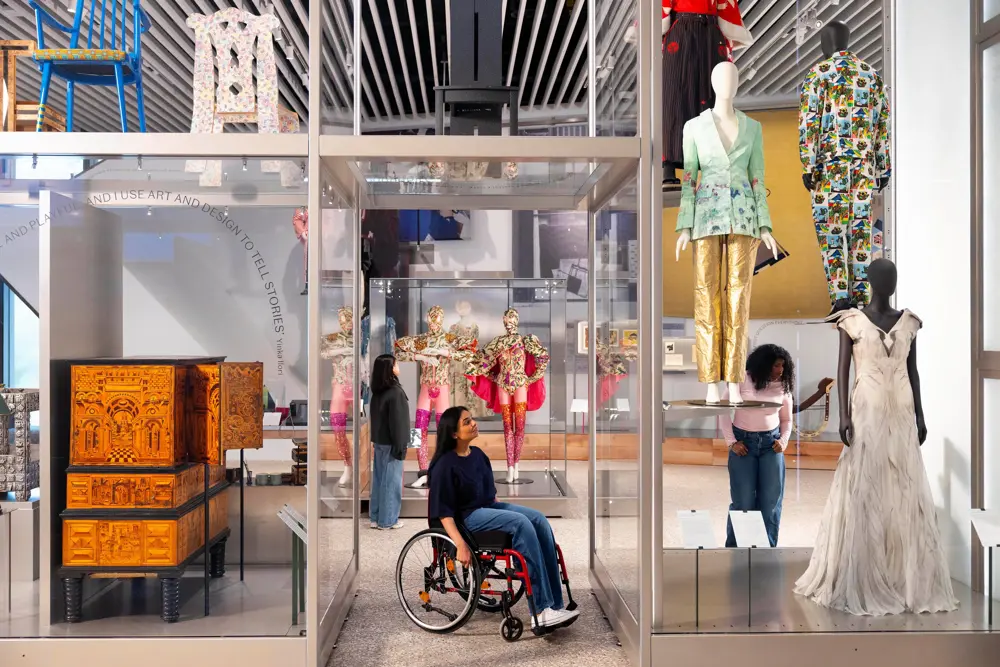 Visitors explore displays of modern and vividly coloured fashion, furniture and design objects inside V&A East.