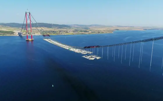 A photo taken from a drone or helicopter showing most of the Canakkale Bridge's central section, with the middle third of the deck mostly in place.