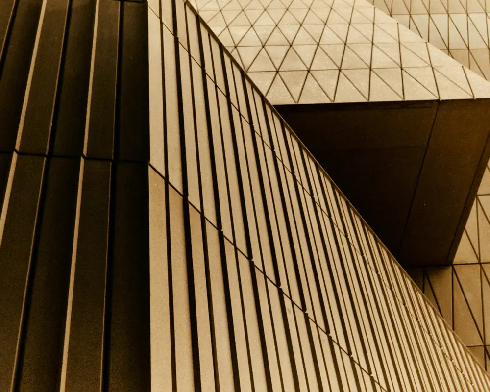 Close-up of the museum’s geometric façade panels, made from a sand-coloured concrete aggregate.