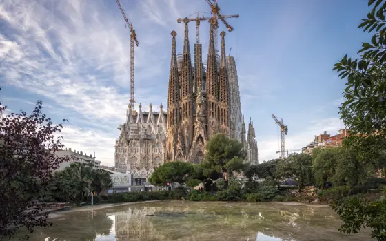 The Sagrada Familia under construction works, with three cranes working on it.