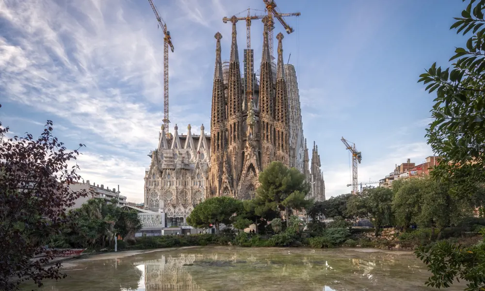 The Sagrada Familia under construction works, with three cranes working on it.