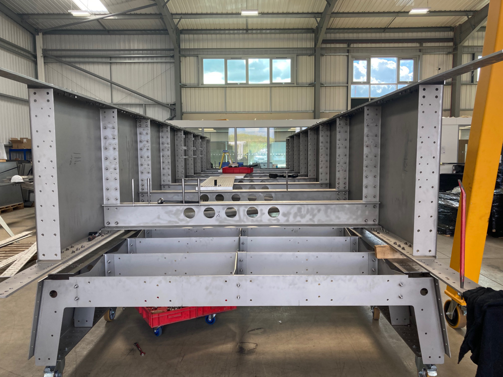 The flat pack footbridge being assembled in a warehouse.