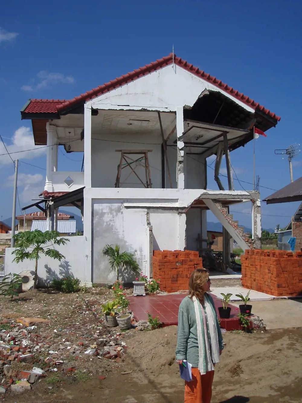 Jo da Silva outside a structurally damaged house in Indonesia after the 2005 tsunami.